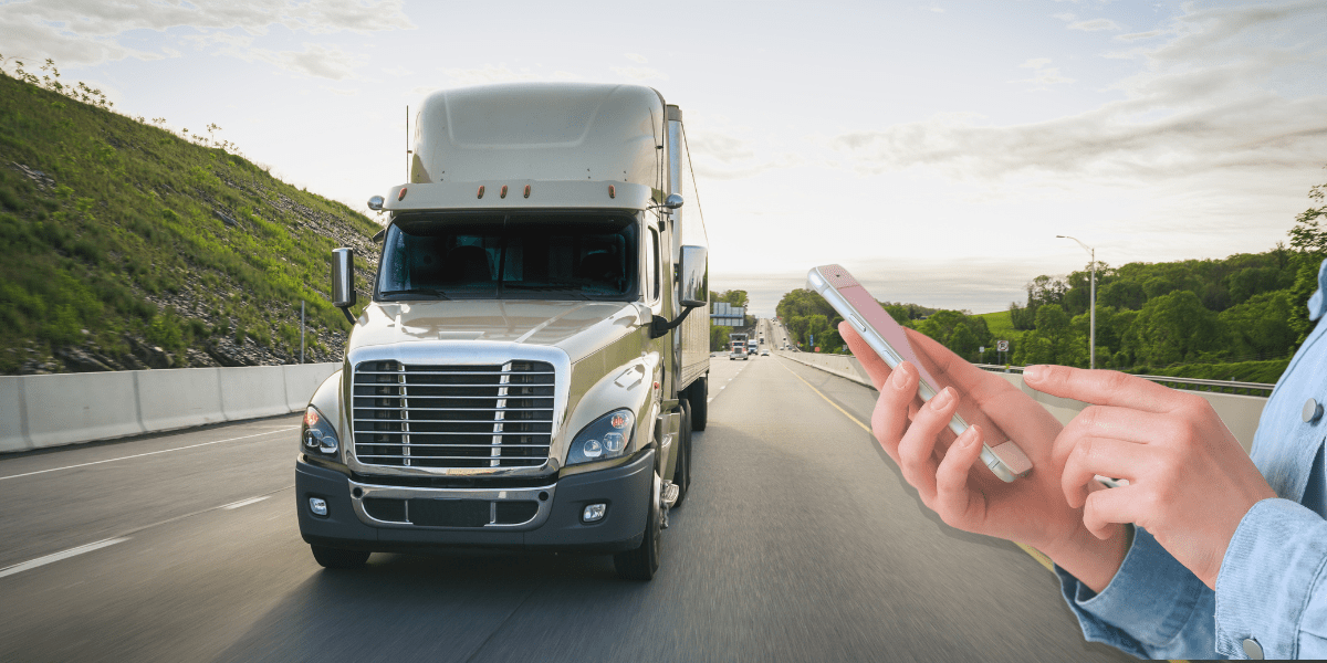 Semi Truck driving down the road in the USA with a hand holding a phone