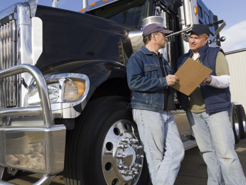 A safety manager and a driver reviewing a record at a terminal
