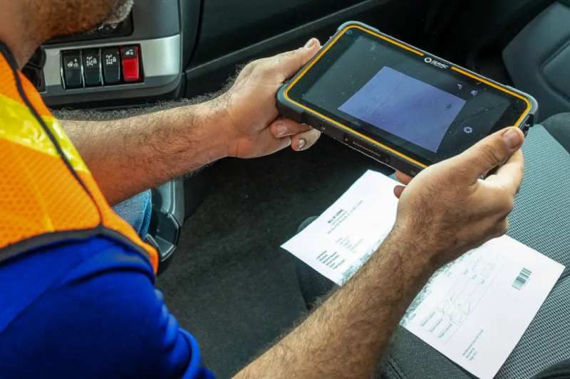 A driver photographing a bill of lading on a phone